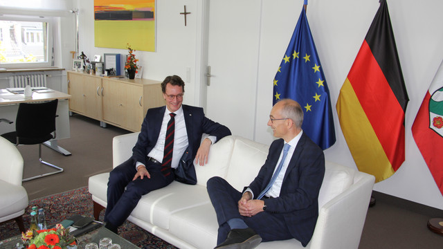 Ministerpräsident Hendrik Wüst und der 1. Vorsitzende des DBB NRW, Roland Staud, sitzen im Gespräch auf einem Sofa in der Staatskanzlei