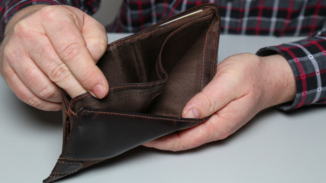 Eine leere Geldbörse in den Händen eines älteren Mannes